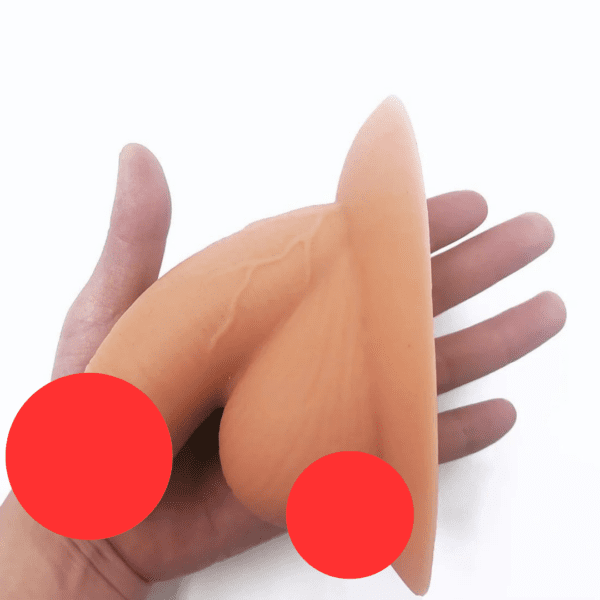 A Caucasian hand holding an MRIMIN Soft Packer prosthetic silicone model of male genitalia against a white background. Red circles cover parts of the model.