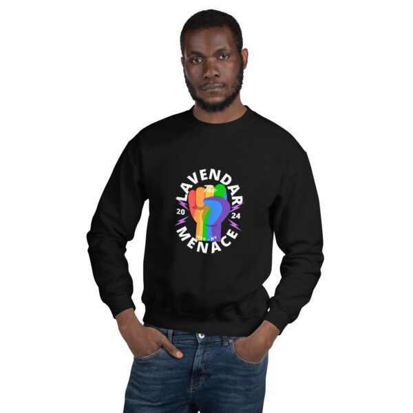 A person wearing a unisex black sweatshirt featuring a colorful design of two fists and the text "Lavender Menace 2024." With short hair and a beard, they stand confidently with hands in pockets against a plain background.